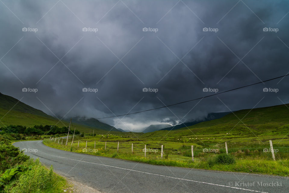 Storm clouds over mountain and road