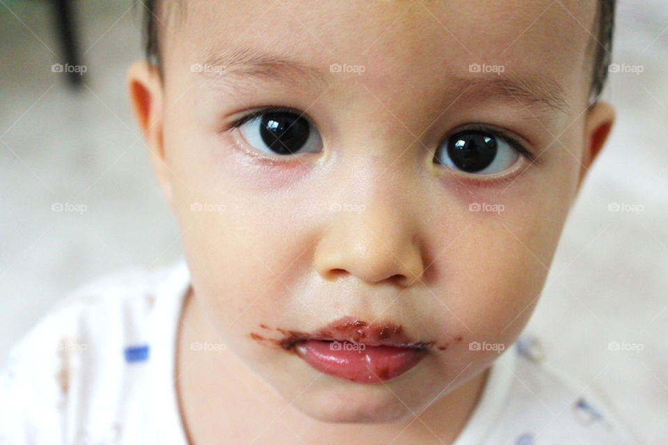 young baby boy mouth full of chocolate 