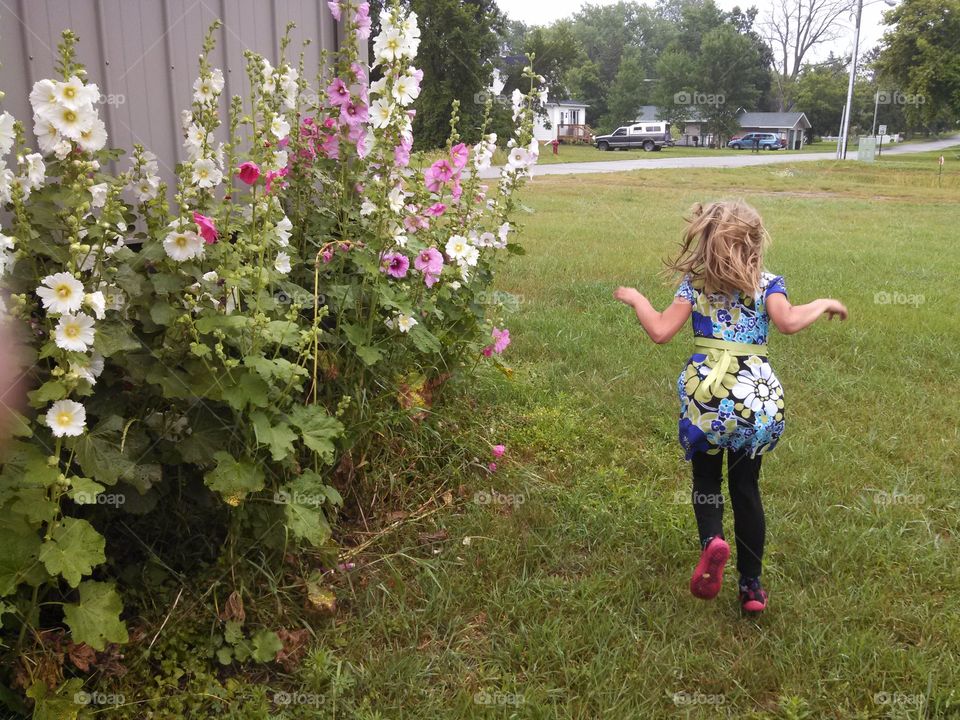 My lil girl. On a short road trip with my daughter we stopped in a small town. I took a few pics of her near these flowers. 