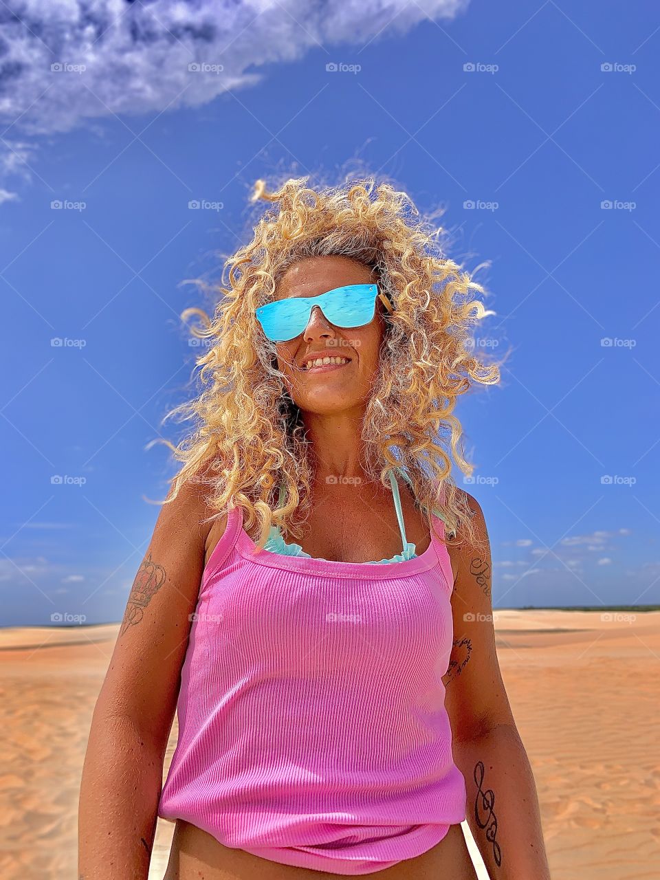 Blonde hair woman with pink clothes against desert and sky