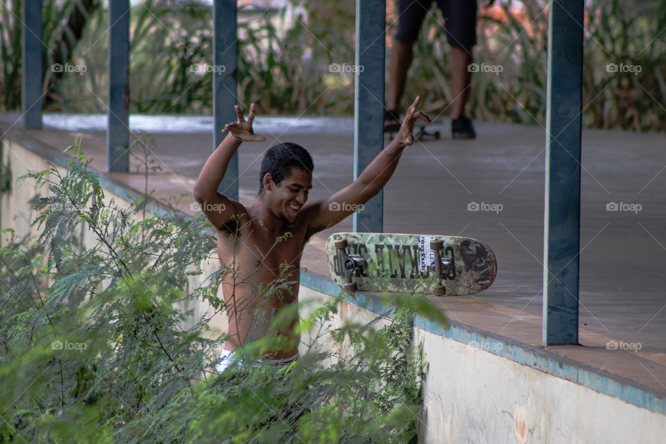 Jovem feliz ao recuperar seu skate.