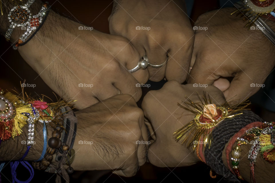 Close up hand fist of human boys friends waring friendship band on arms. Teamwork confident togetherness positivity expression celebration and spirit gesture. Team unity united hands together concept