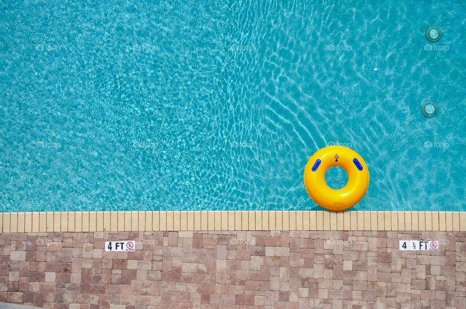 Swimming pool. Looking down on a swimming pool with a yellow pool ring floating in it