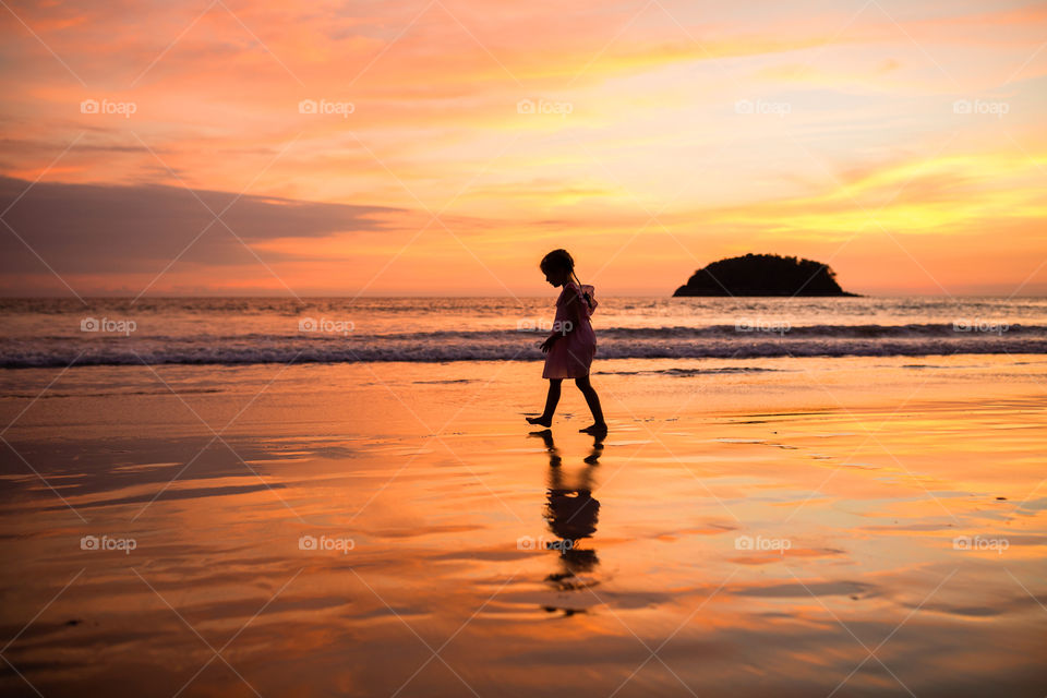 Silhouette of little girl on the beach 