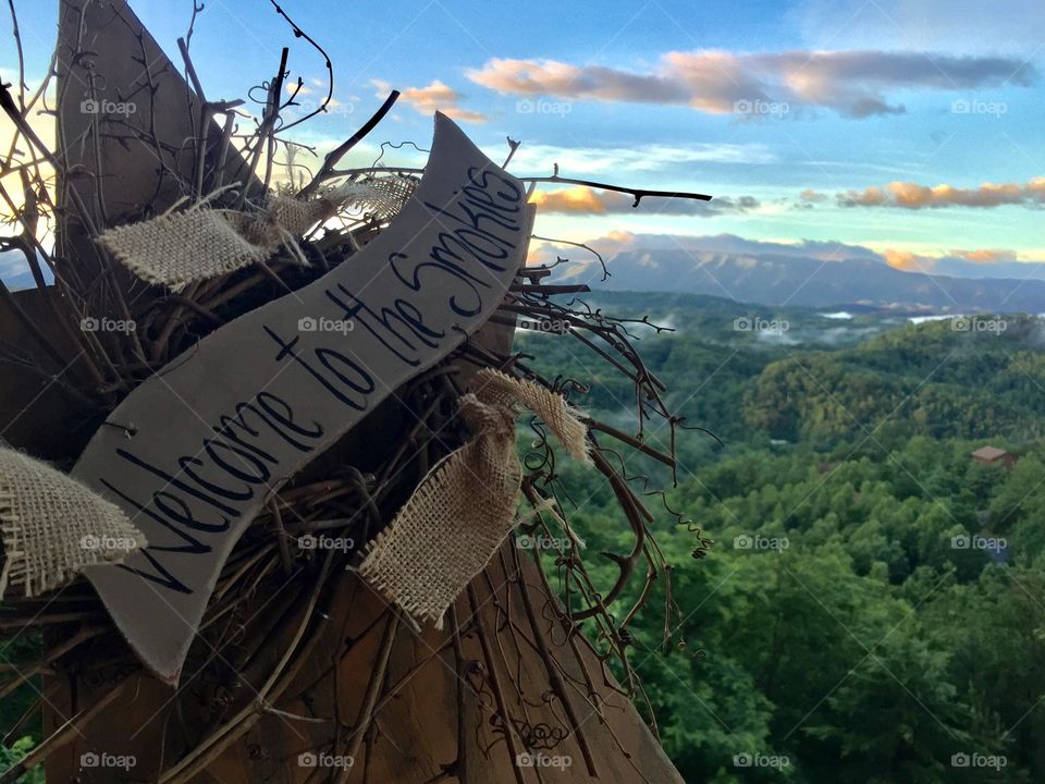 This Welcome to the Smokies sign give a glance into the majestic mountains previewed behind it