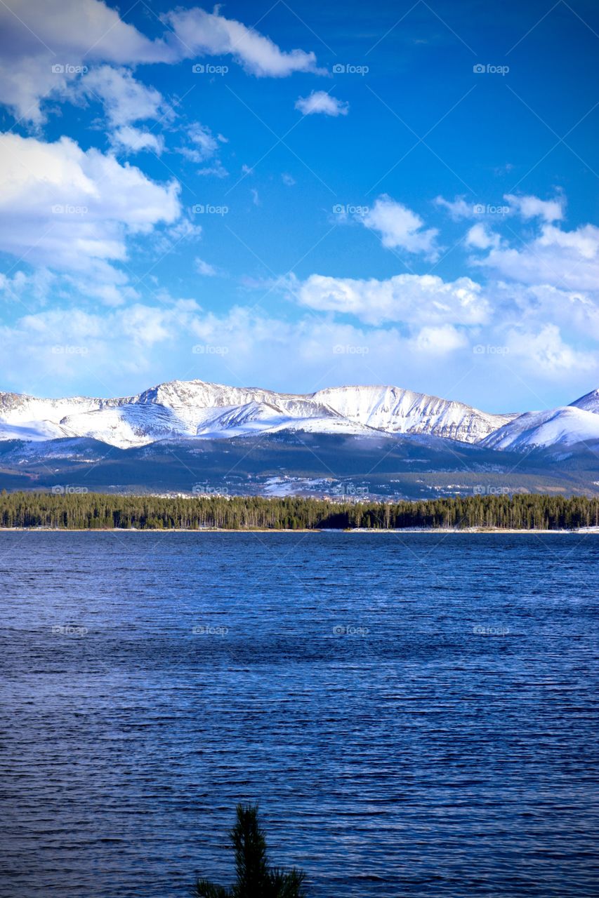 A snow covered mountain range across the lake.