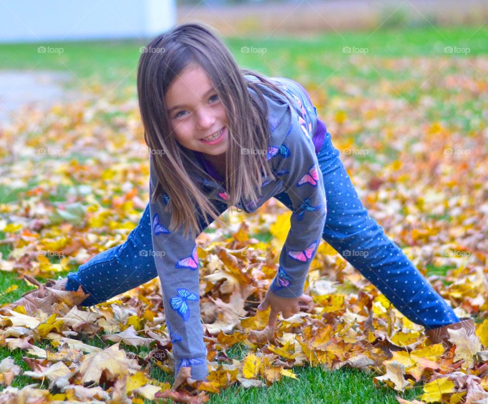 Smiling girl playing in park during autumn