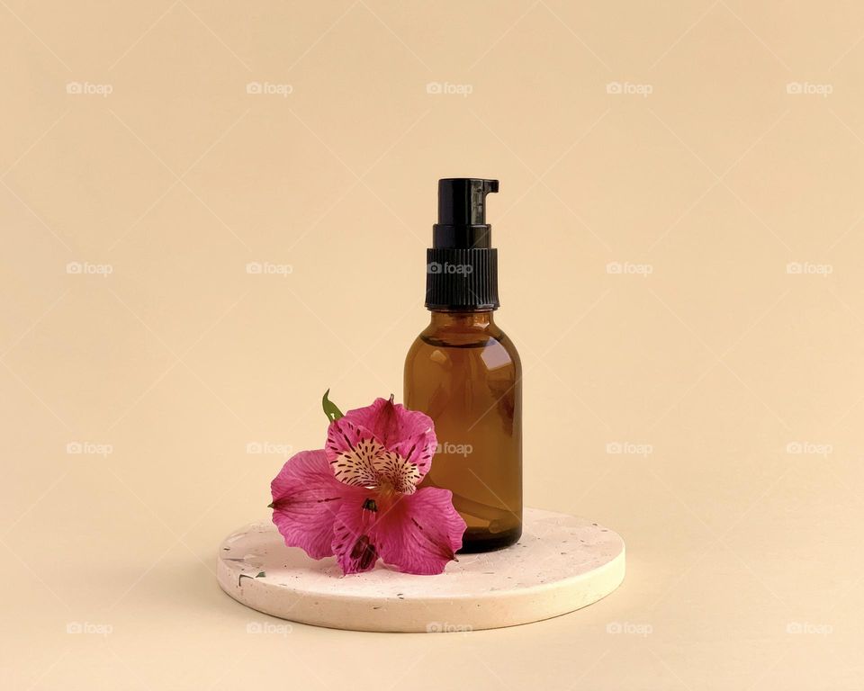 Concrete podium, glass bottle, pink flower, minimalistic on beige
