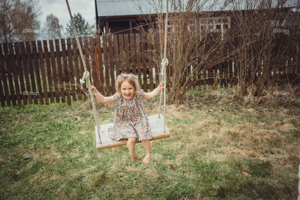 Little girl has fun on swing