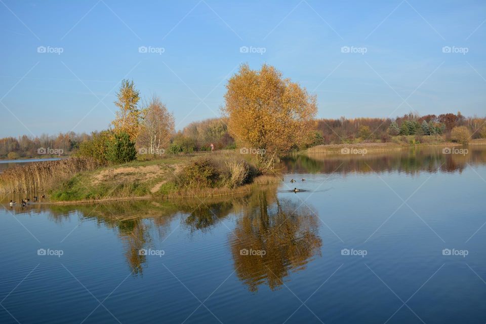 beautiful autumn nature landscape lake shore and reflection and person walking best place for resting