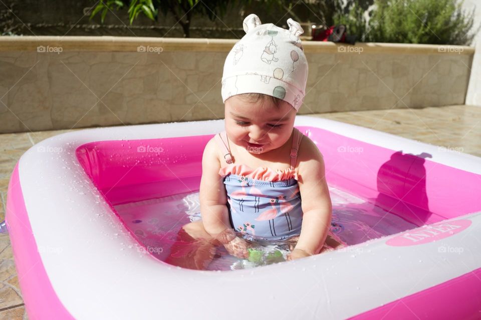 little girl in the pool in summer