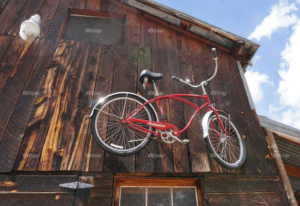 Bicycle hanging on a barn wall outside