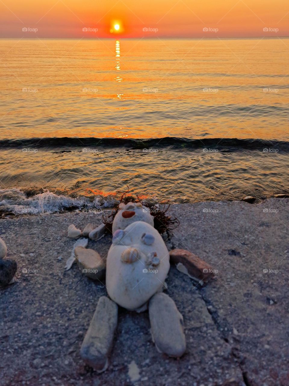 the stone doll standing on the beach