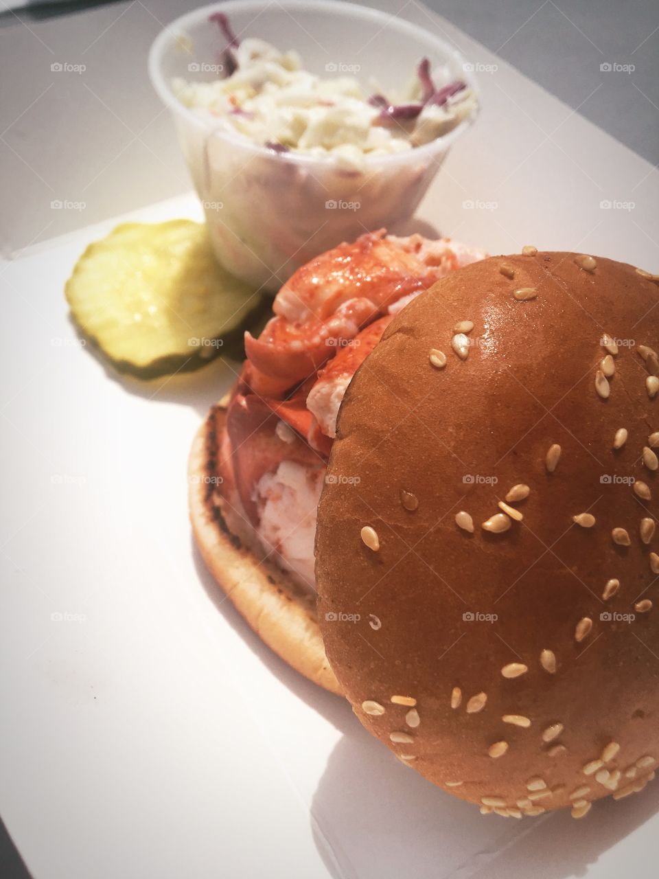 A classic New England lobster roll complete with a pickle and coleslaw 