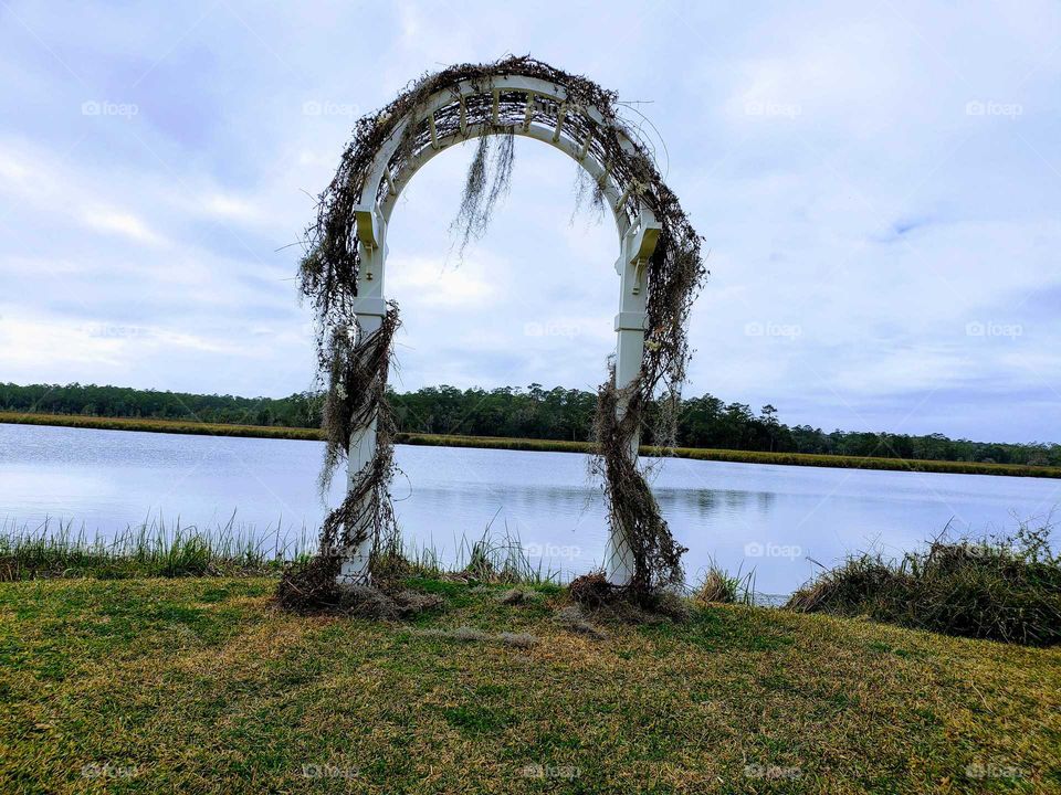 Vine covered wedding arch on Florida Gulf Coast River.