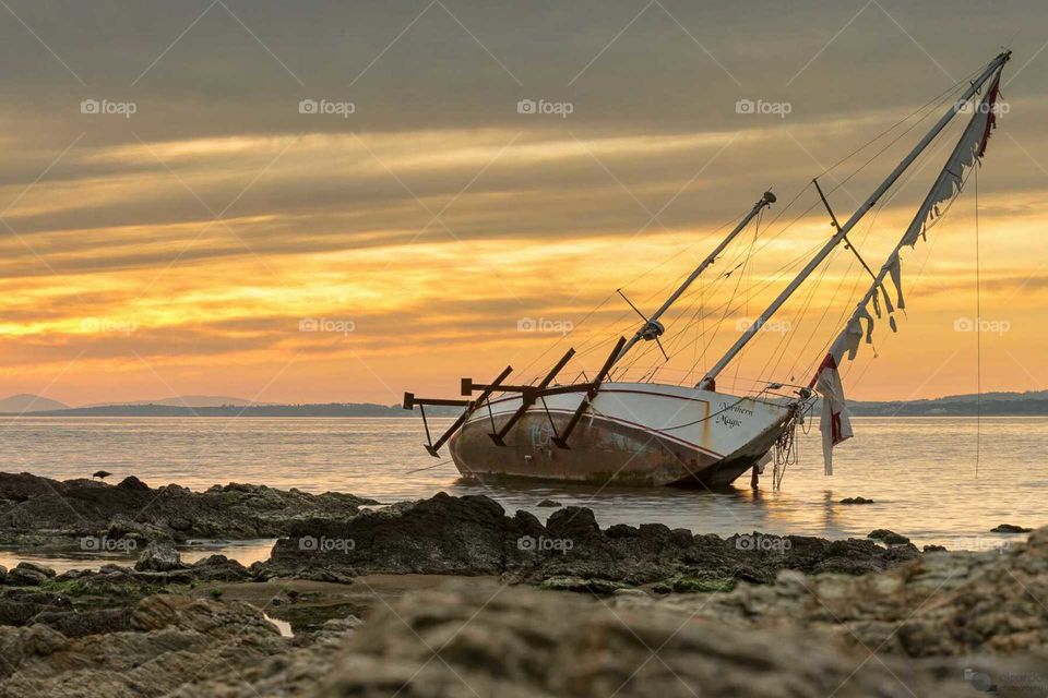 After the storm.  Shipwrek of a sailboat at Punta Del Este's harbour, during the sunset.  Punta del Este, Maldonado,  Uruguay.
