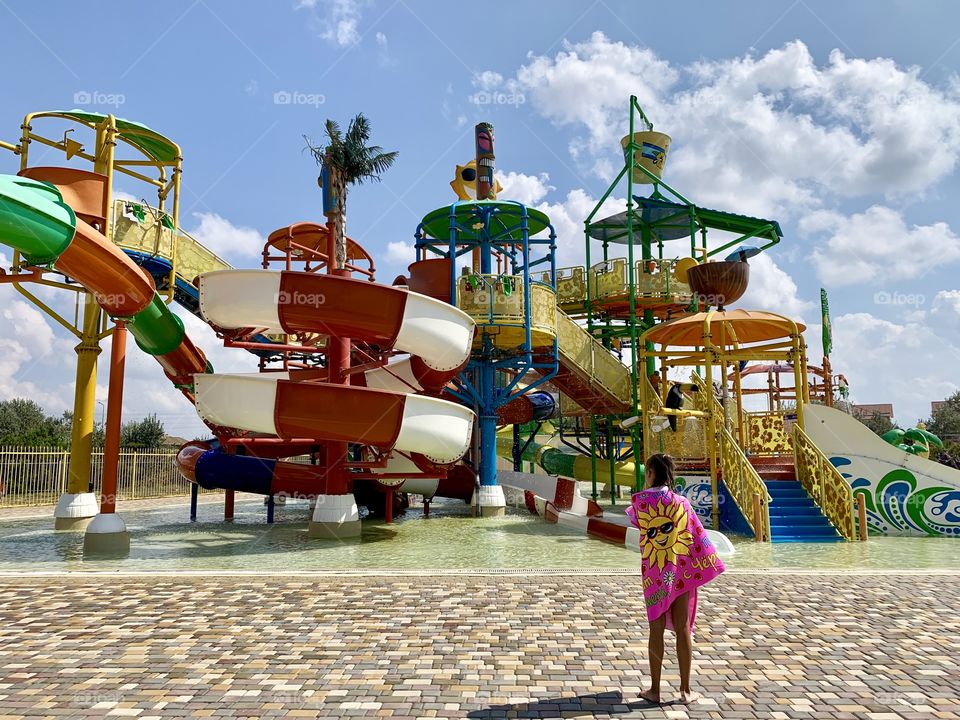 open air children's entertainment area with slides in the water park. The girl in the water park.