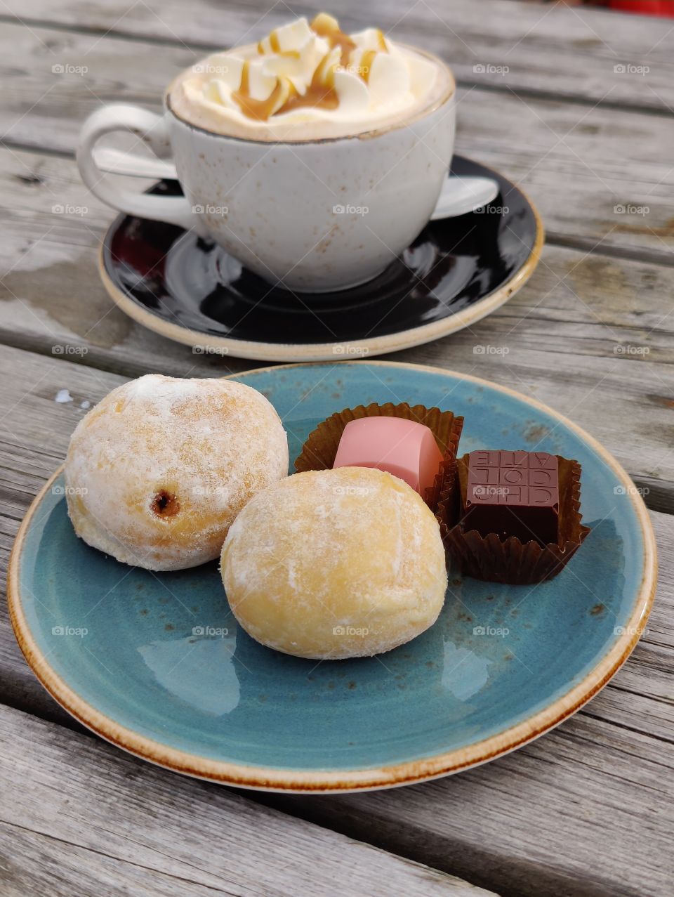 Coffee with a sidekick: chocolates and cookies on a blue saucer