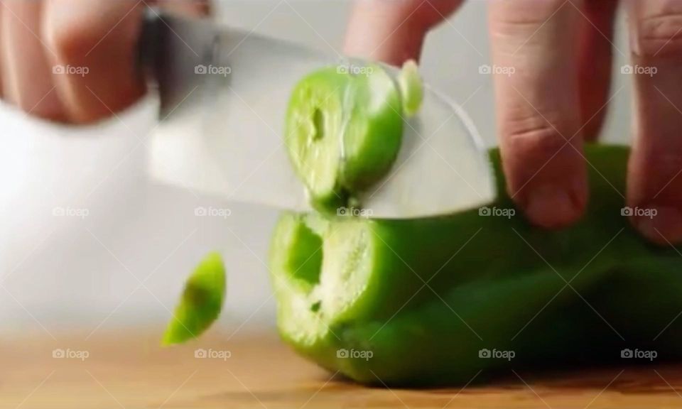 hand cutting green bell pepper