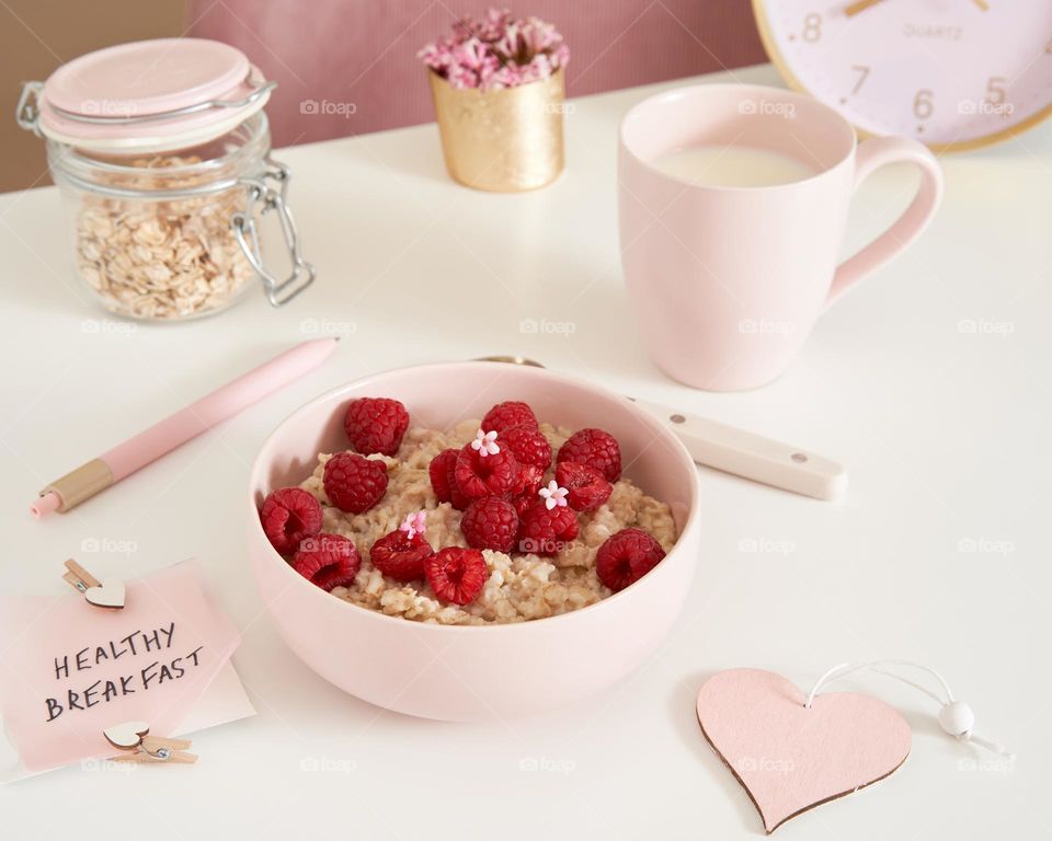A bowl of oatmeal with raspberry.