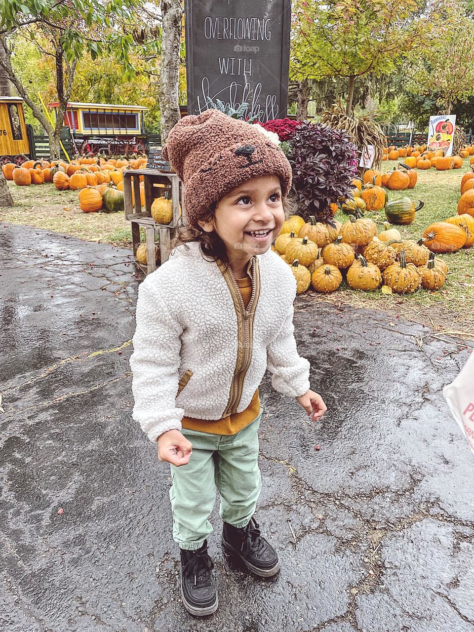 Toddler girl very excited about pumpkin patch, toddler lives fall, toddler at a pumpkin patch, excited about autumn, toddler having fun with pumpkins 