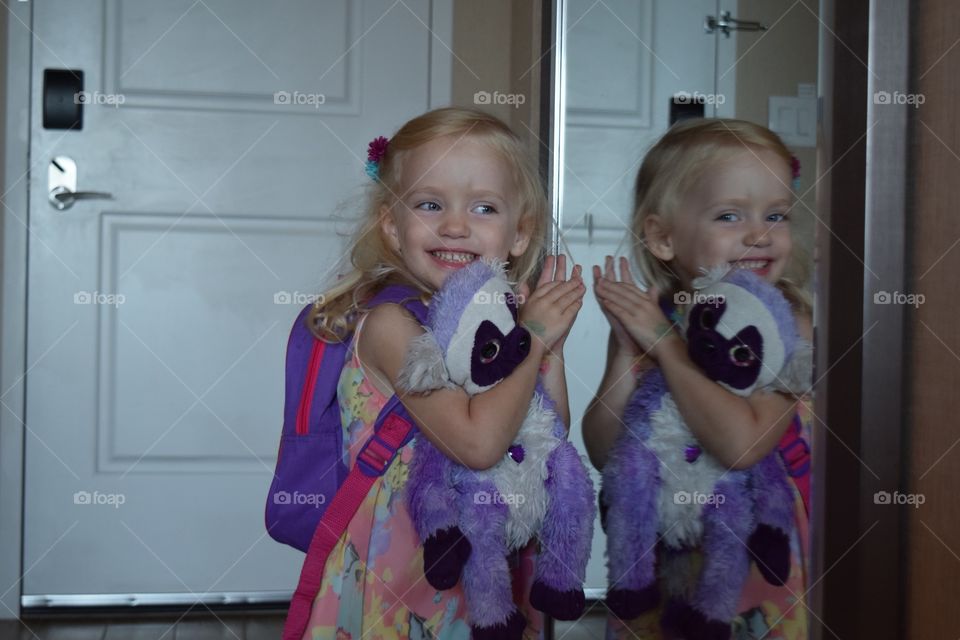 Little girl laughing at her reflection 