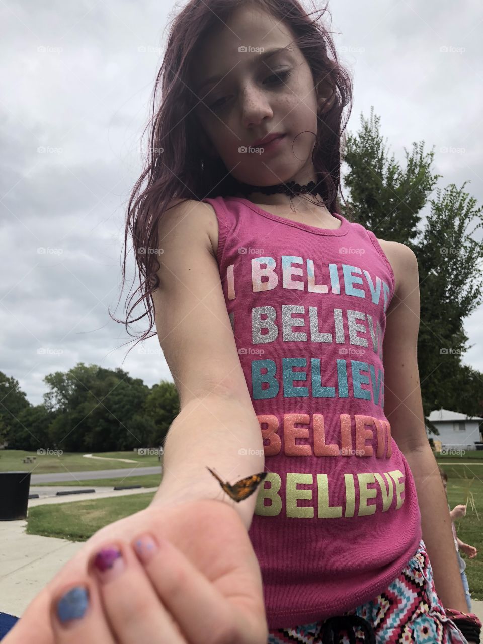 Tiny butterfly landed on her arm happy and peaceful 
