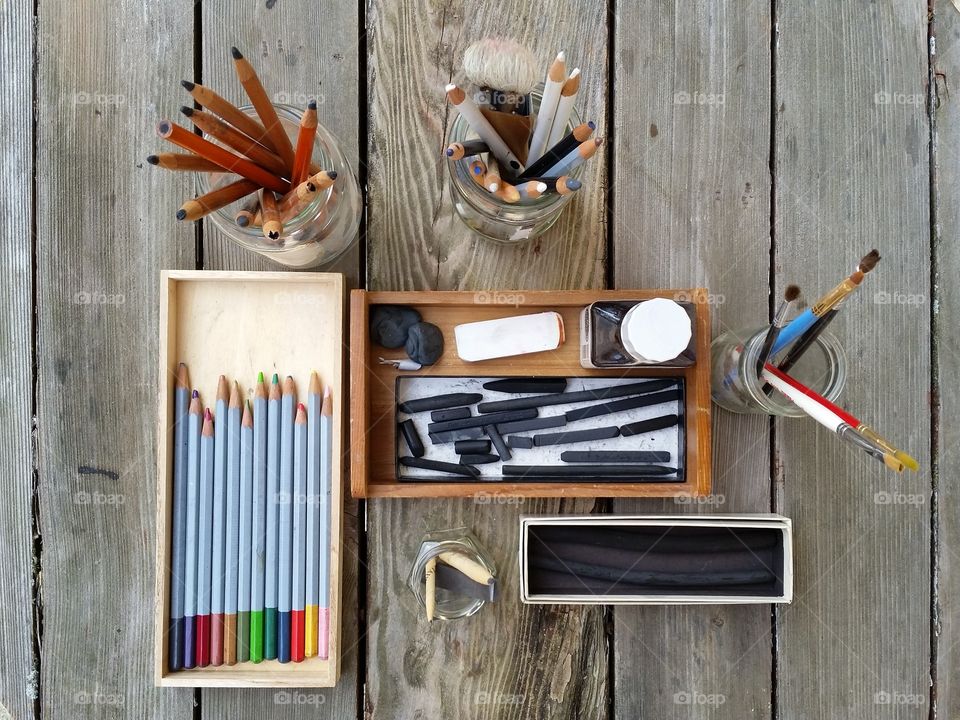 Flat lay of artists drawing and painting supplies on wooden table