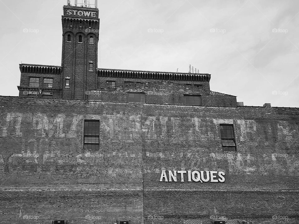 A building that would be considered Antique proclaims that it houses a store selling Antiques