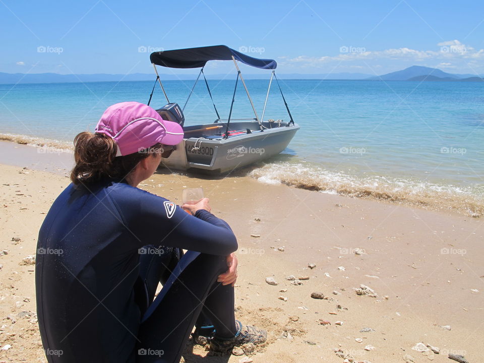 Girl on beach In sun suit, pink cap