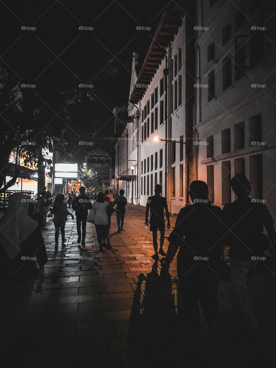 Silhouette and shadow of people walking in the town square of the city.