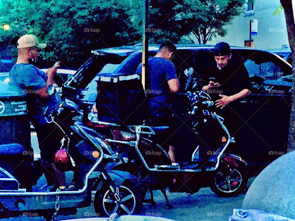 Motorcyclists attending to their bikes and socializing on a late afternoon near twilight time in Long Island City, Queens, NY in the vicinity of Vernon Jackson Avenue and 48th St. 2020. Hypnotic Productions