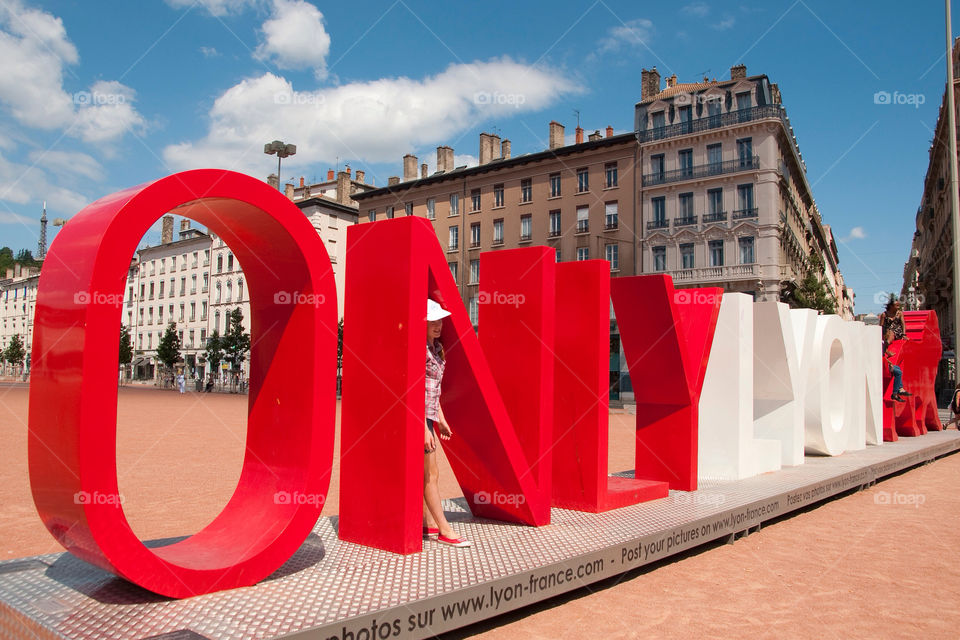 Woman posing in front of the only Lyon  sculpture in the town square