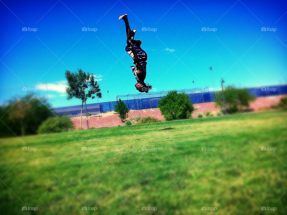 Matrix shot . Kid in the park practicing his flips 