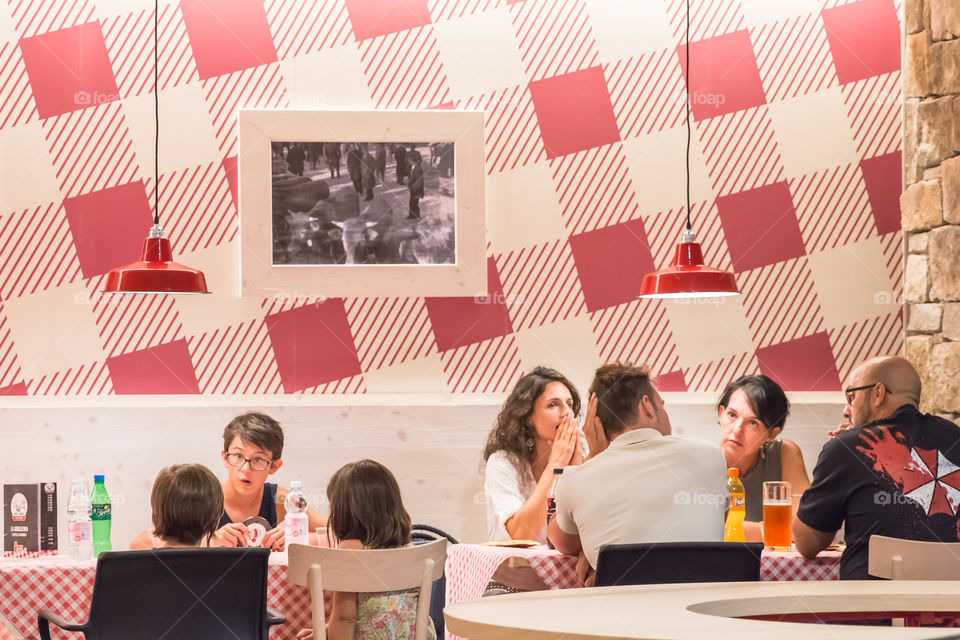 Couples With Their Kids Enjoying Meal At A Fast Food Restaurant
