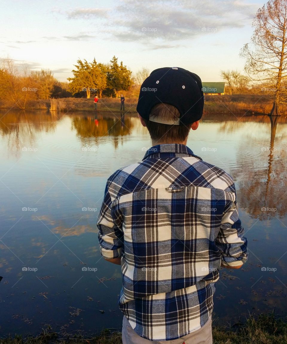 Boys fishing in a Texas pond by a cabin