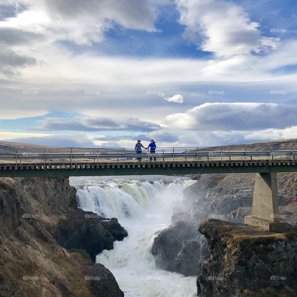 Hand holding over waterfall in Iceland