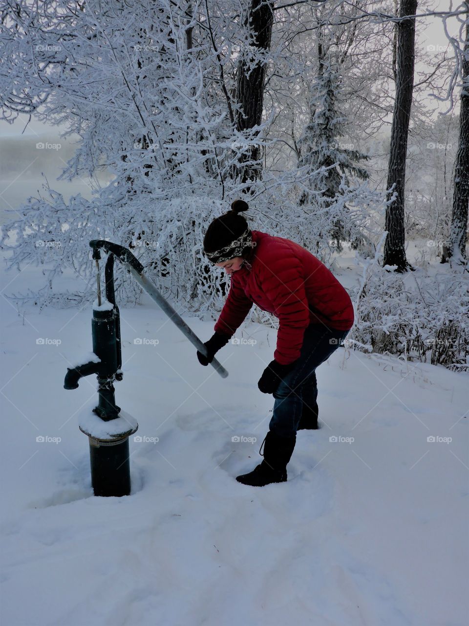 Woman holding water pump snowy landscape