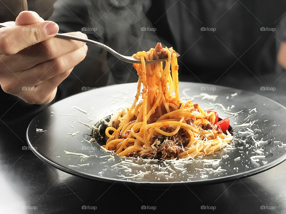 Young man eating a hot italian pasta with seafood 