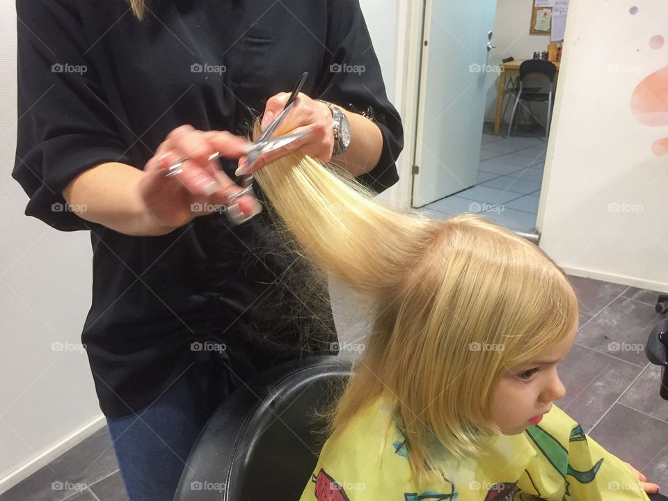 Little girl at the hairdresser at a local saloon in Malmö Sweden.