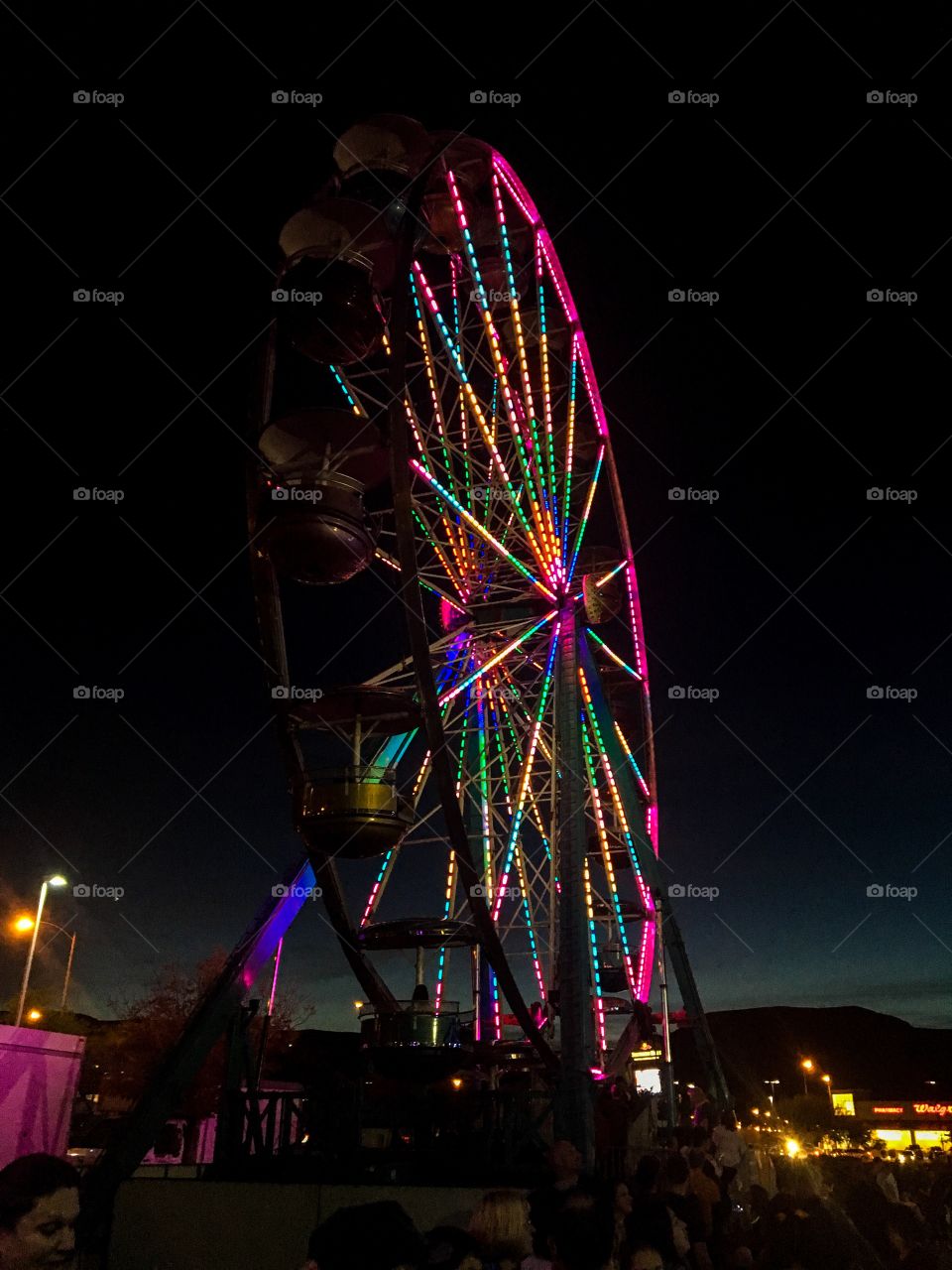 Illuminated ferris wheel against clear sky