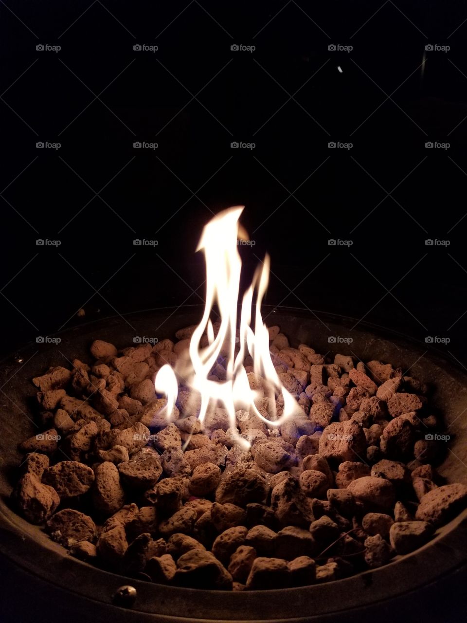 Burning fire over coals in a fire pit in the darkness