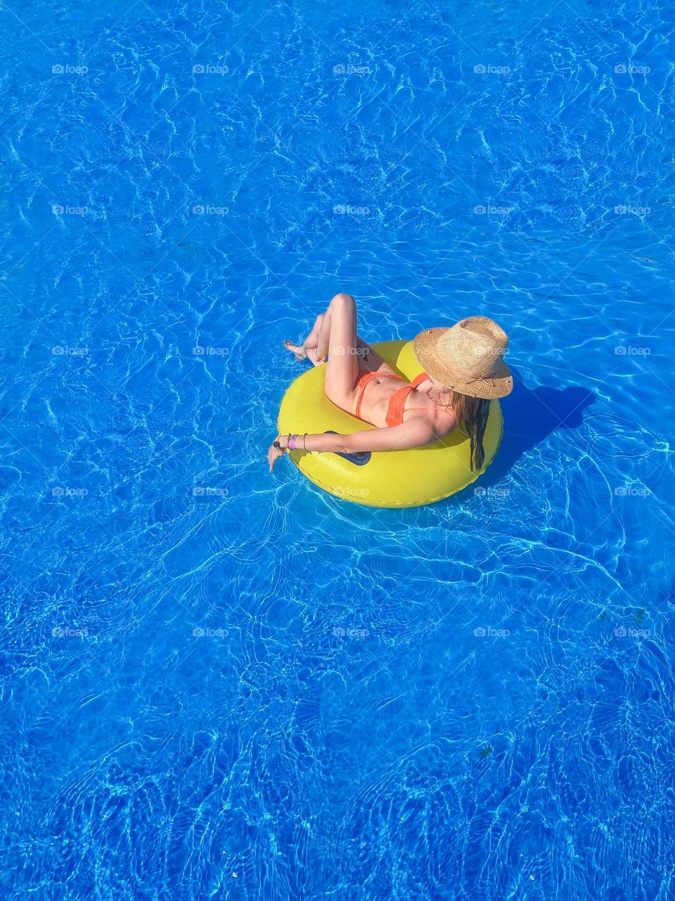 A woman swims in a pool on an inflatable circle