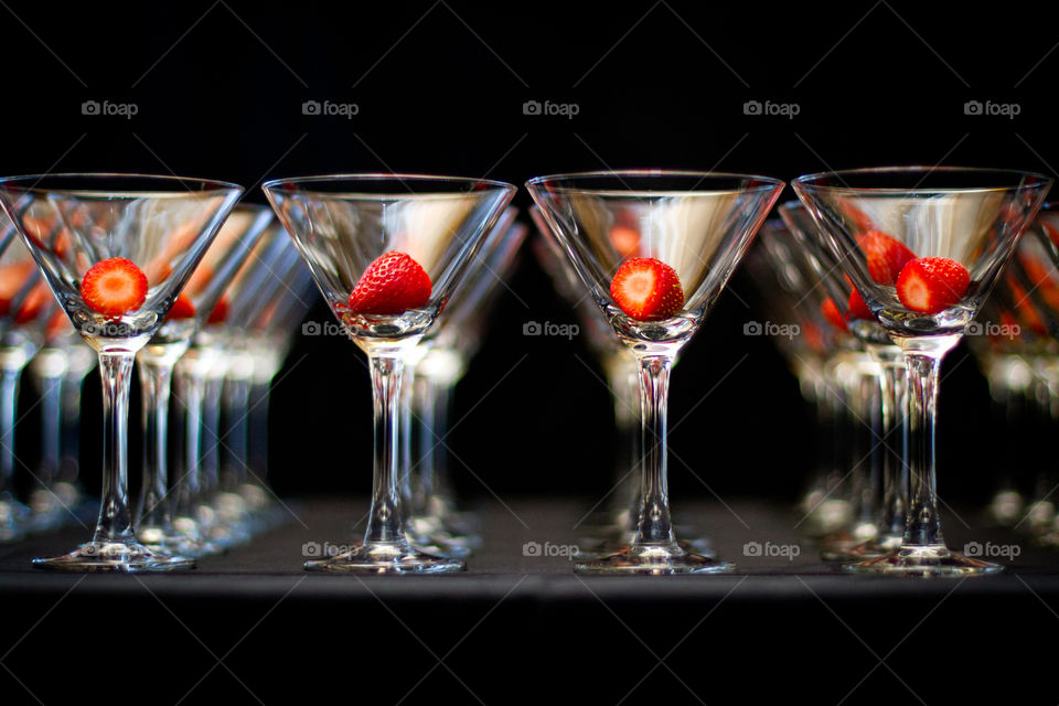 Abstract image of glasses and strawberries on black background