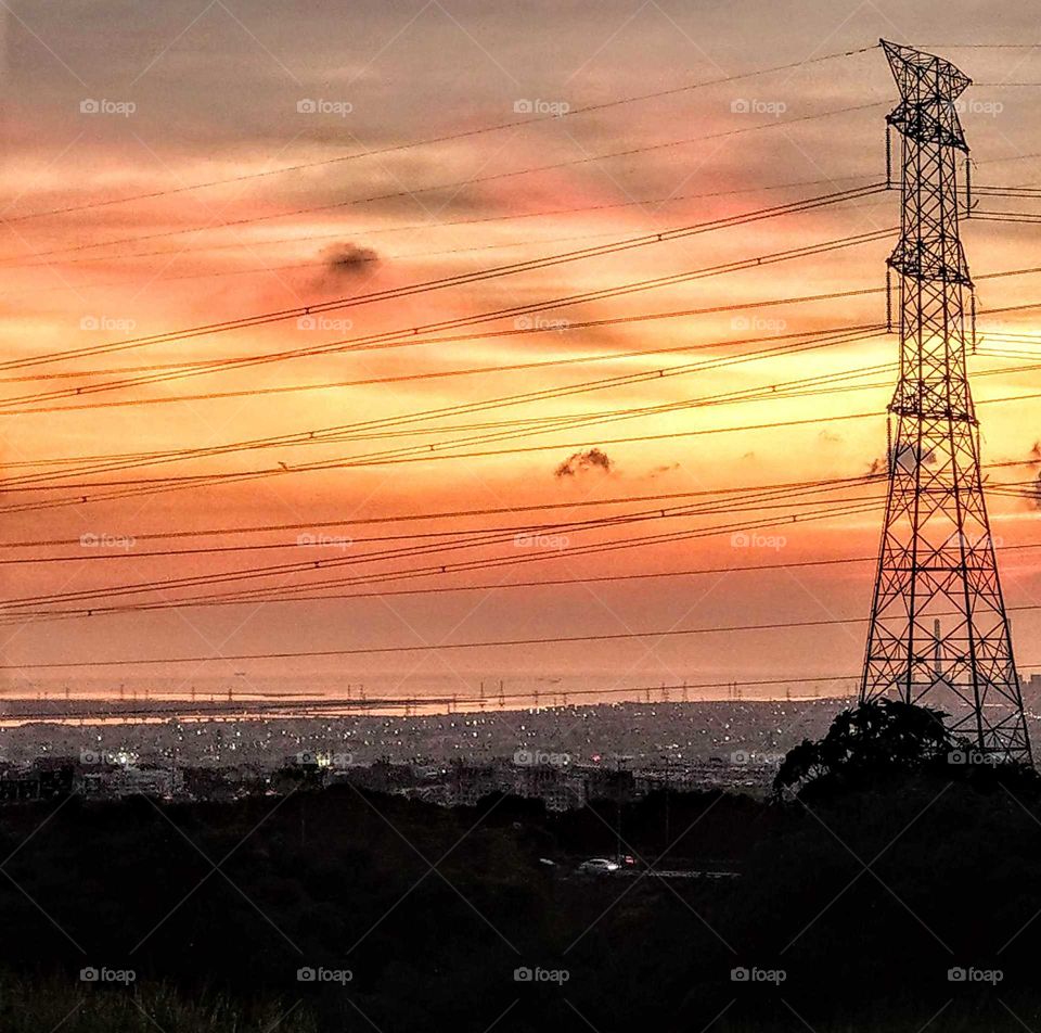 looking the foot of a hill at dusk. beautiful sky and scenery. river and sea junction, and city lights.