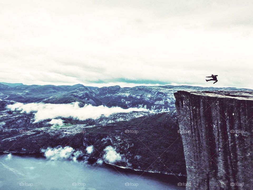 Jumping silhouette on the top of Prekestolen rock. 