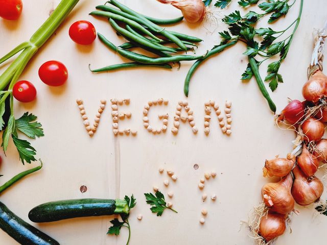 Cutting board with vegetables and vegan written made with chickpeas