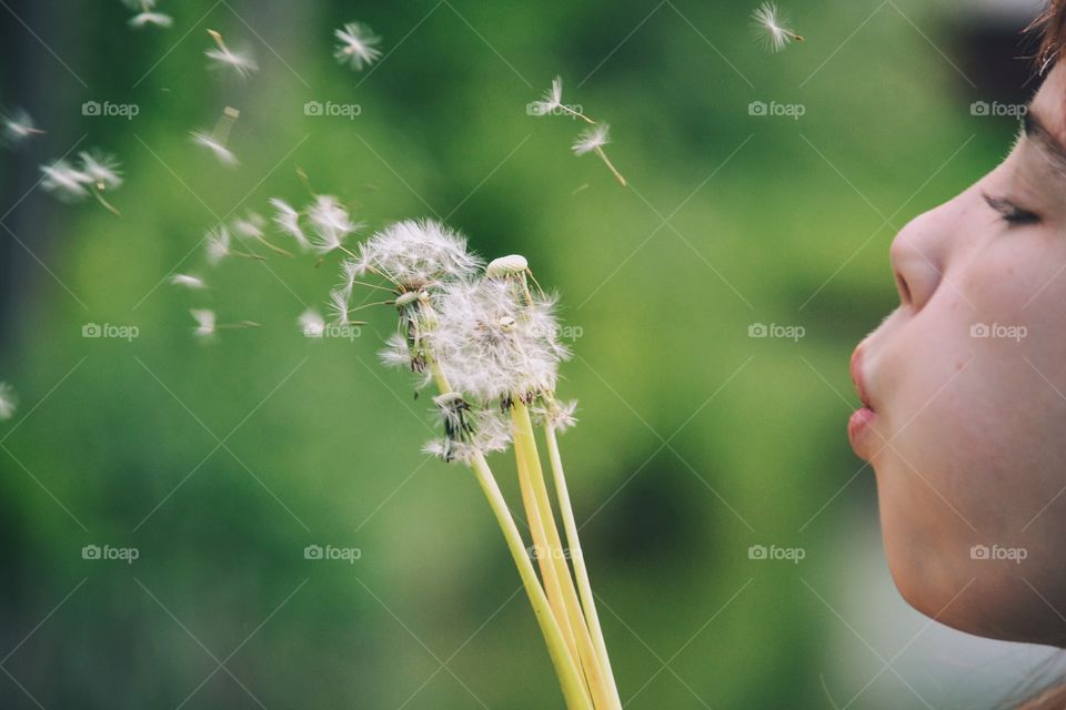 Girl blowing dandelion seeds