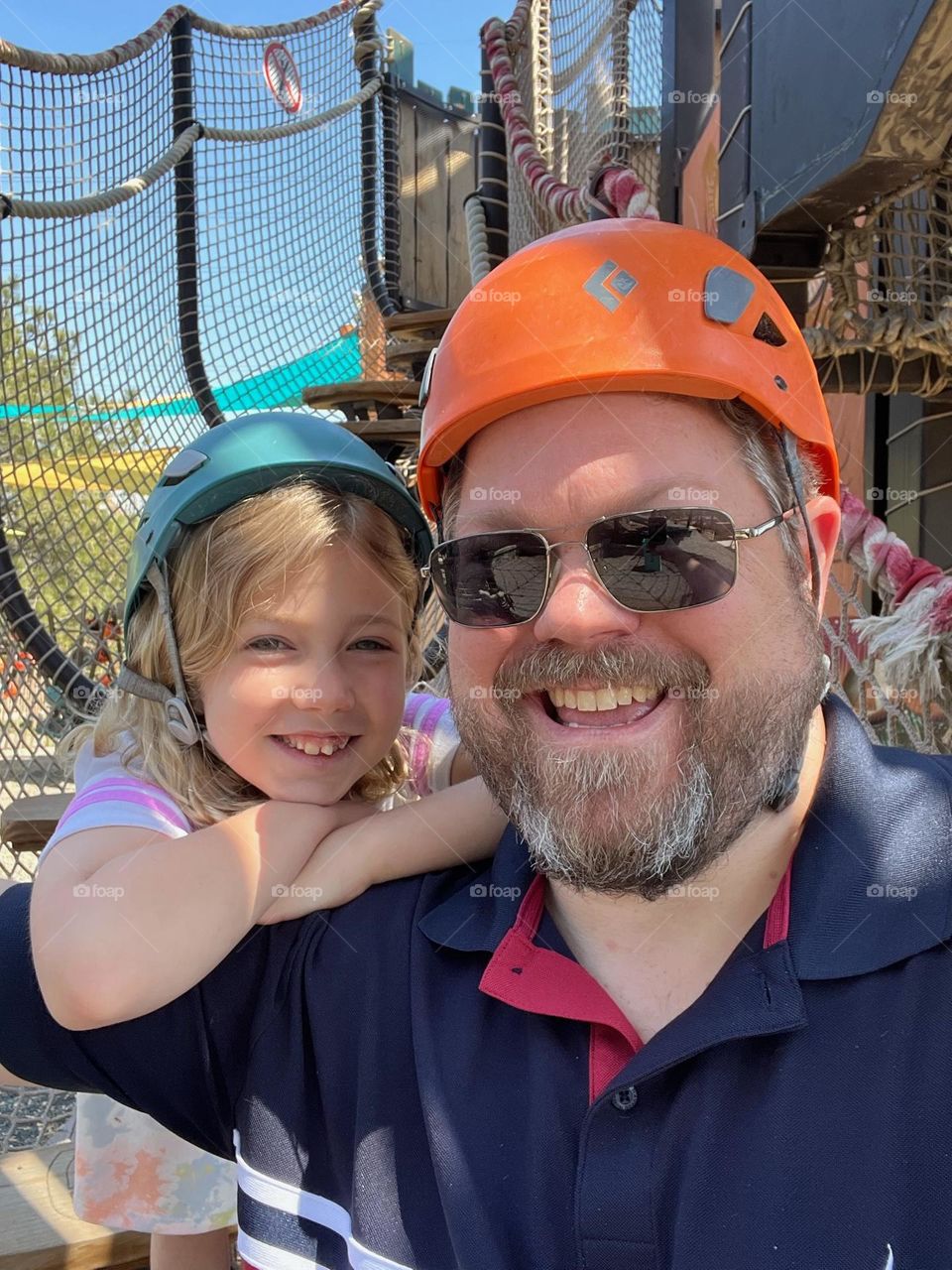 Father and daughter taking a picture before climbing the obstacle course 