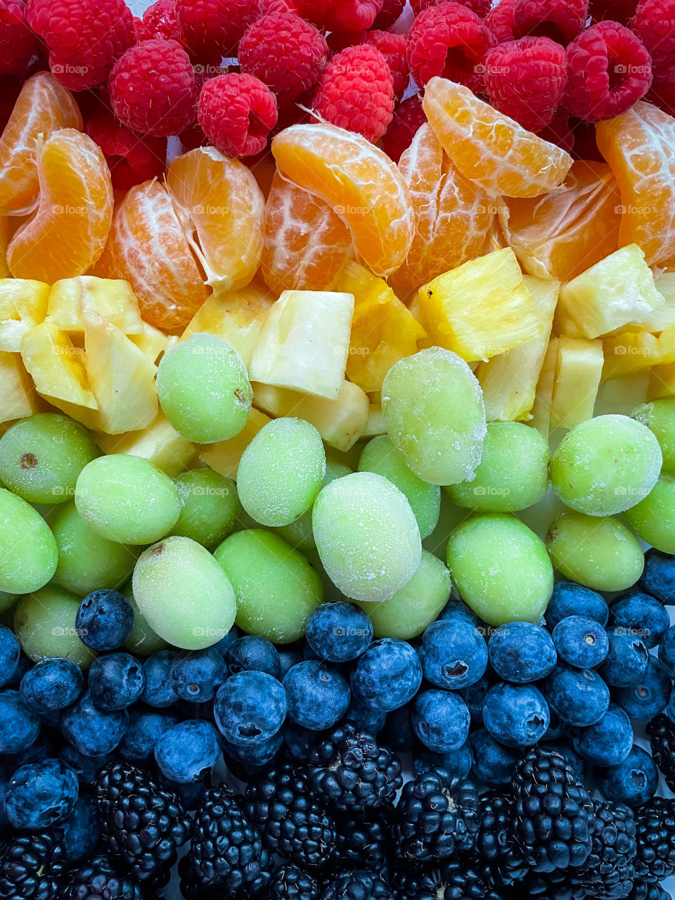 Rainbow of fruit. Raspberry, orange, pineapple, grape, blueberry, and blackberry. Eat the rainbow. 